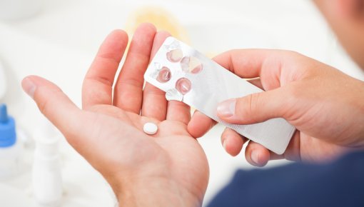 Photo of someone taking tablets out of the package