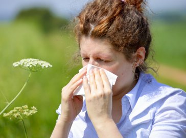 Photo of a woman blowing her nose