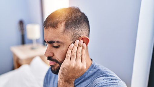 Photo of a young man holding his ear