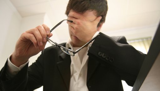 Photo of a man holding his head in pain