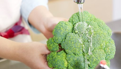 Photo of a woman washing broccoli
