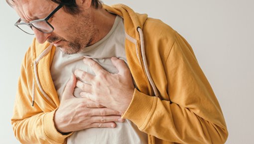 Photo of man holding his chest in pain