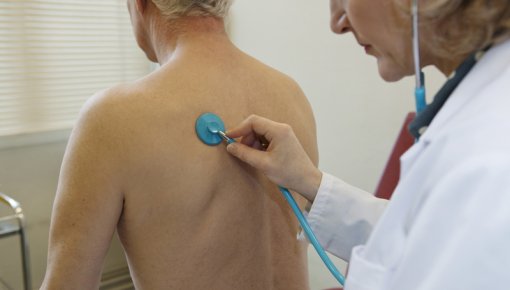 Photo of a doctor listening to a patient’s lung