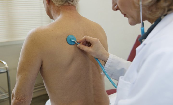 Photo of a doctor listening to a patient’s lungs