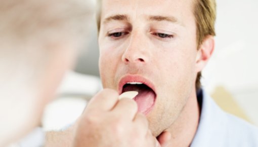 Photo of doctor examining a patient with tonsillitis