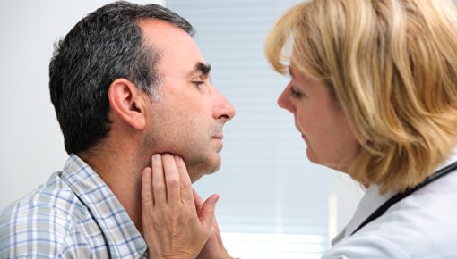 Photo of a doctor examining a patient’s throat