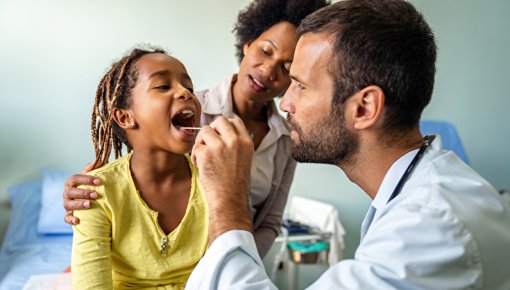 Photo of doctor looking into a girl's mouth