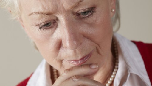 Photo of a woman reading the print on a drug package