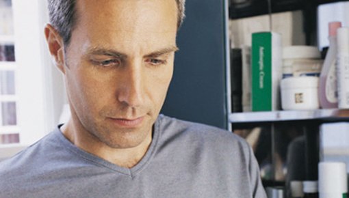 Photo of man looking at a packet of tablets