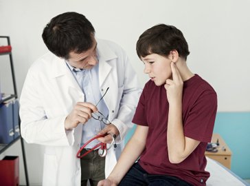 Photo of a boy being examined by a doctor