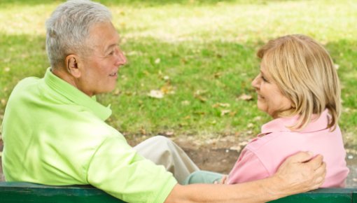 Photo of an older couple sitting on a park bench