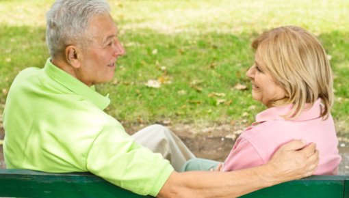 Photo of an older couple sitting on a park bench