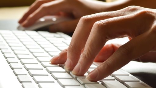 Photo of hands on a computer keyboard