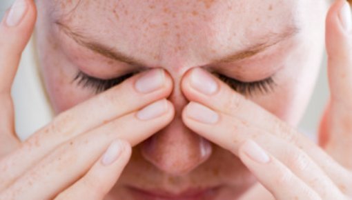 Photo of woman holding her face in pain