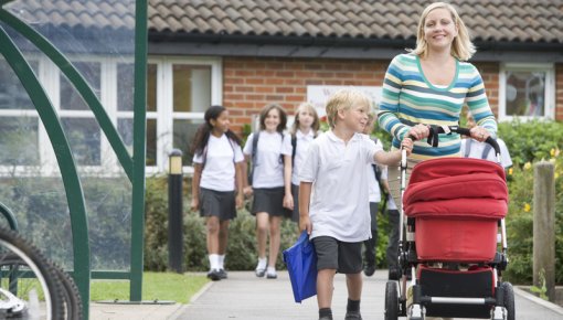 Photo of a mother walking with her son and pushing a stroller