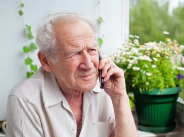 Photo of an elderly man sitting on a balcony
