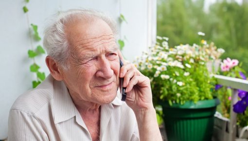 Photo of an elderly man sitting on a balcony