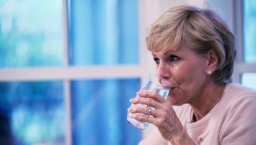 Photo of a woman drinking a glass of water