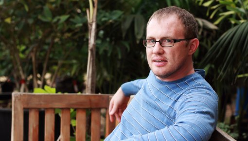 Photo of a man sitting on a garden bench