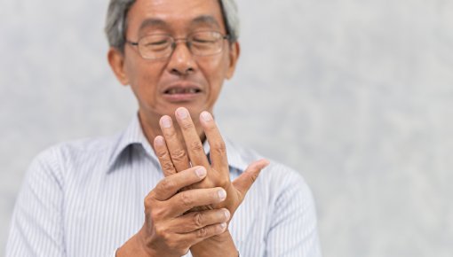 Photo of a man holding his hand in pain