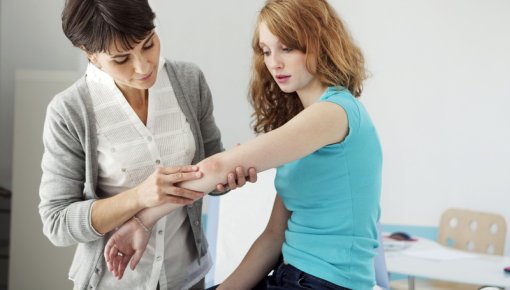 Photo of a teenage girl being examined by a doctor