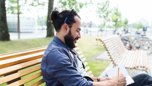 Photo of a man writing in a diary