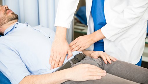 Photo of a doctor examining a patient's lower belly