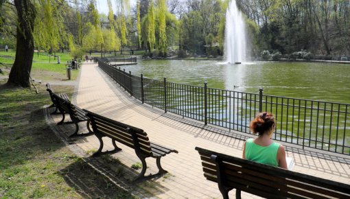 Photo of a woman sitting near a pond