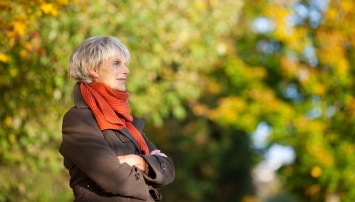 Photo of a woman standing by some trees