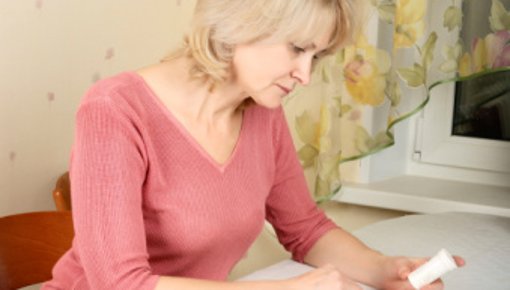 Photo of a woman reading a package insert