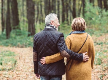 Photo of couple walking in forest, seen from behind