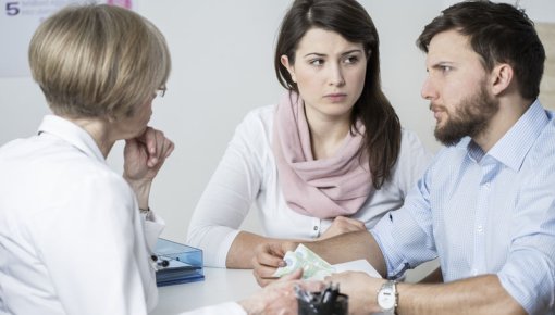 Photo of a couple talking with a gynecologist