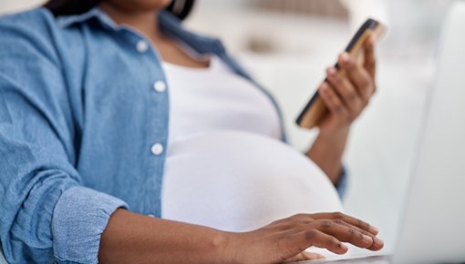 Photo of a pregnant woman holding a phone
