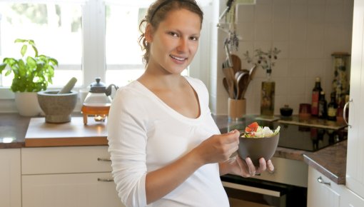 Photo of a pregnant woman with a salad
