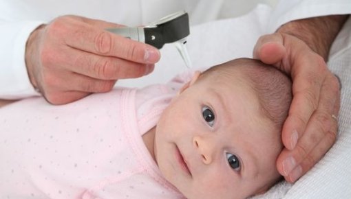 Photo of a baby being examined by a doctor