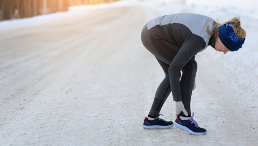 Photo of a jogger holding her ankle 