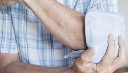 Photo of a man holding a cool pack on his elbow