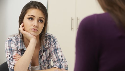 Photo of a teenage girl talking to a doctor