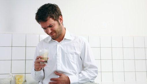 Photo of a man holding his stomach in pain