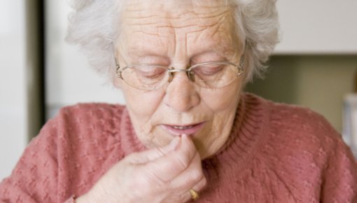 Photo of an older woman taking a tablet