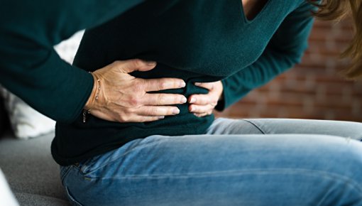 Photo of a woman holding her belly in pain