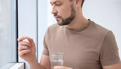 Photo of a man taking a tablet