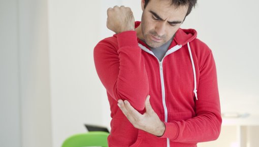 Photo of a man holding his elbow