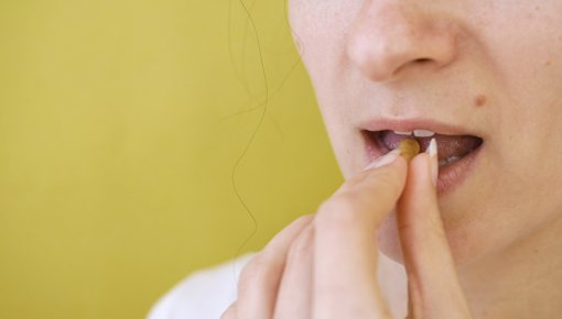 Photo of woman taking tablets