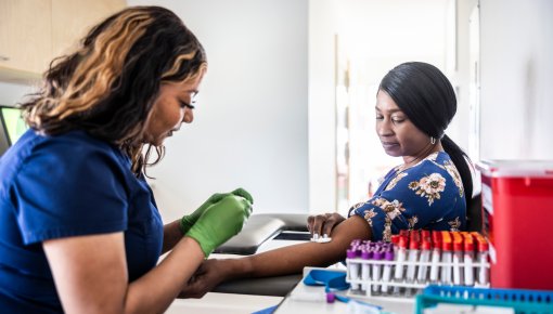 Photo of a doctor taking a sample of blood from a patient