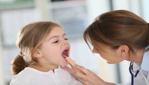 Photo of a doctor looking into a girl's mouth