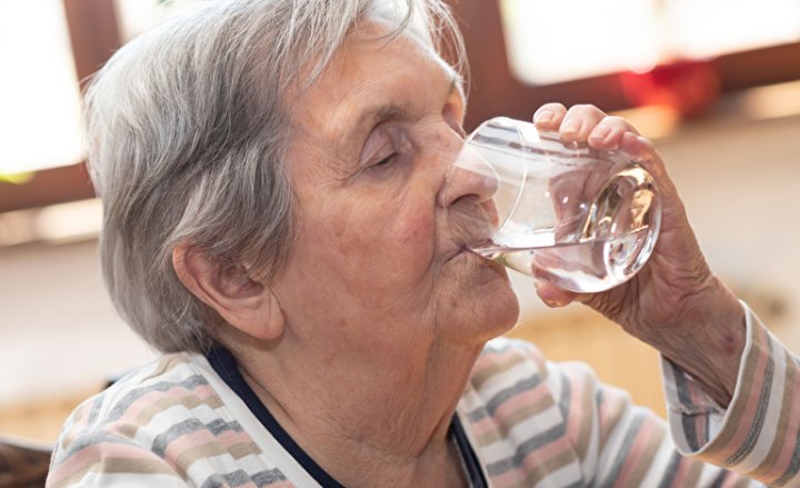 Photo of an elderly woman drinking water