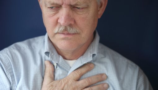 Photo of a man holding his chest