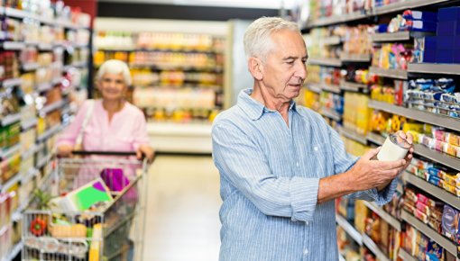 Photo of a man in a supermarket reading food labels