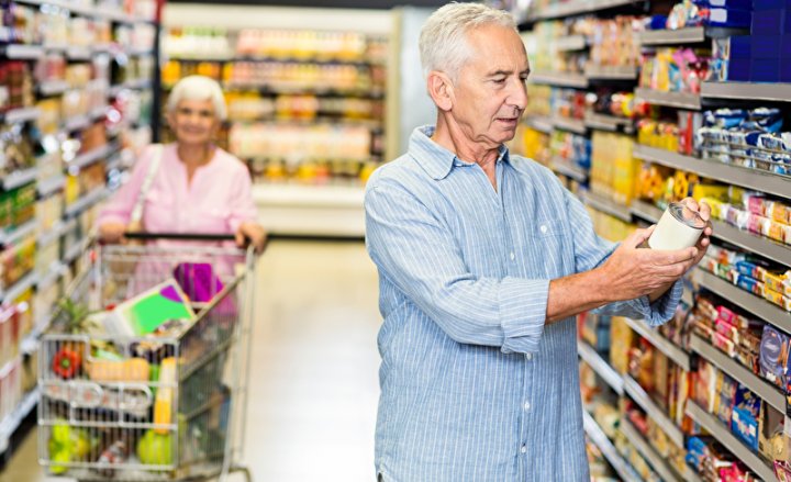 Photo of a man in a supermarket reading food labels